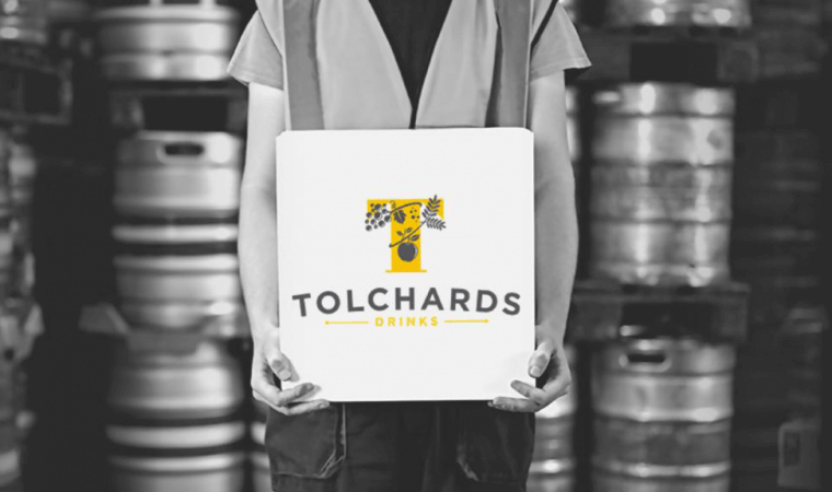 man holding a box with Tolchards branding on it