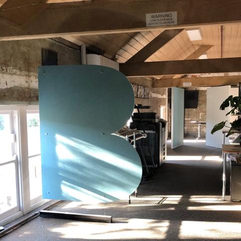 Large letter B metal sculpture in a room 